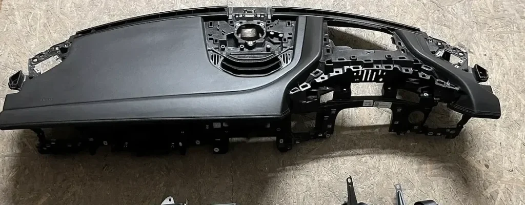 A dashboard frame with the airbag opening on the workshop floor